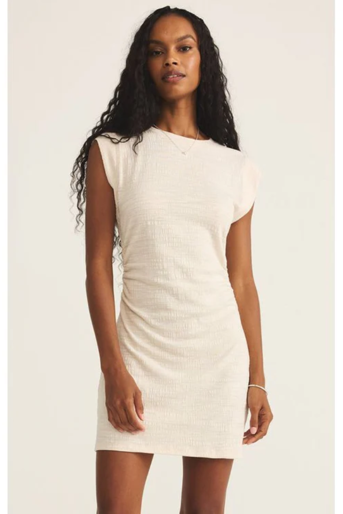 Woman wearing a white dress against a plain background