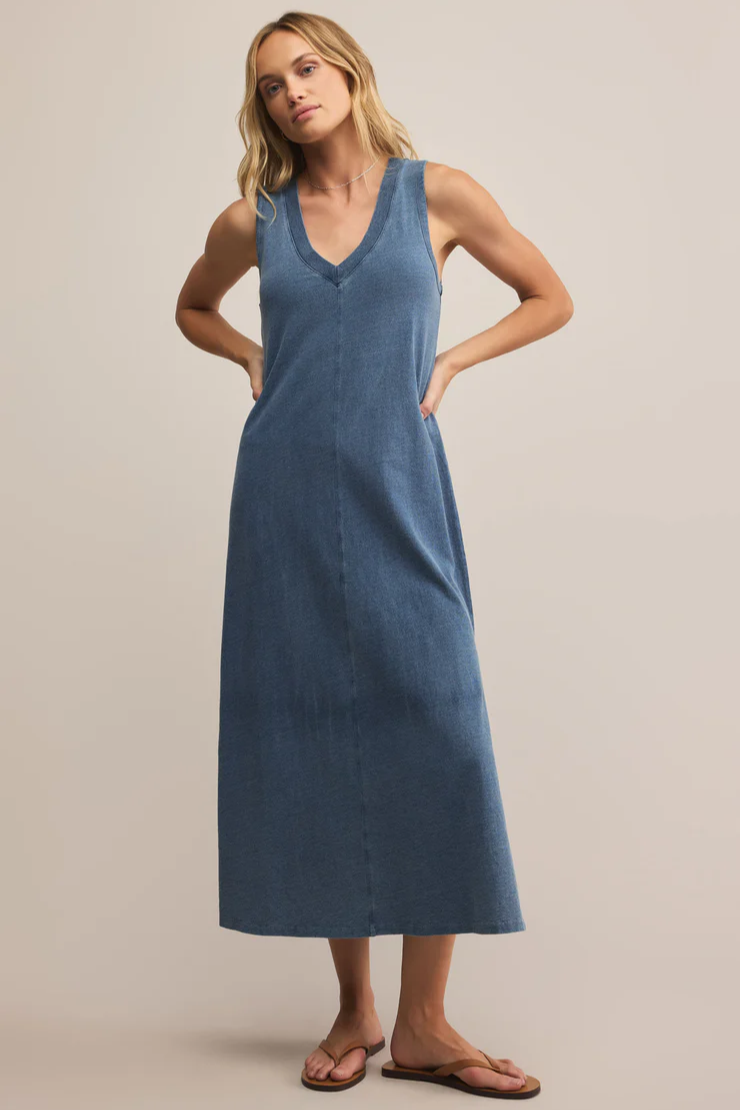 Woman wearing a blue dress against a beige background