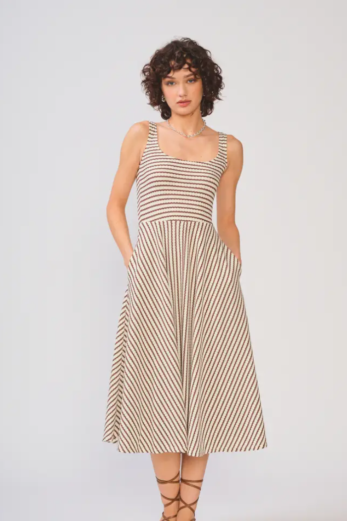 Woman wearing a striped dress on a plain background