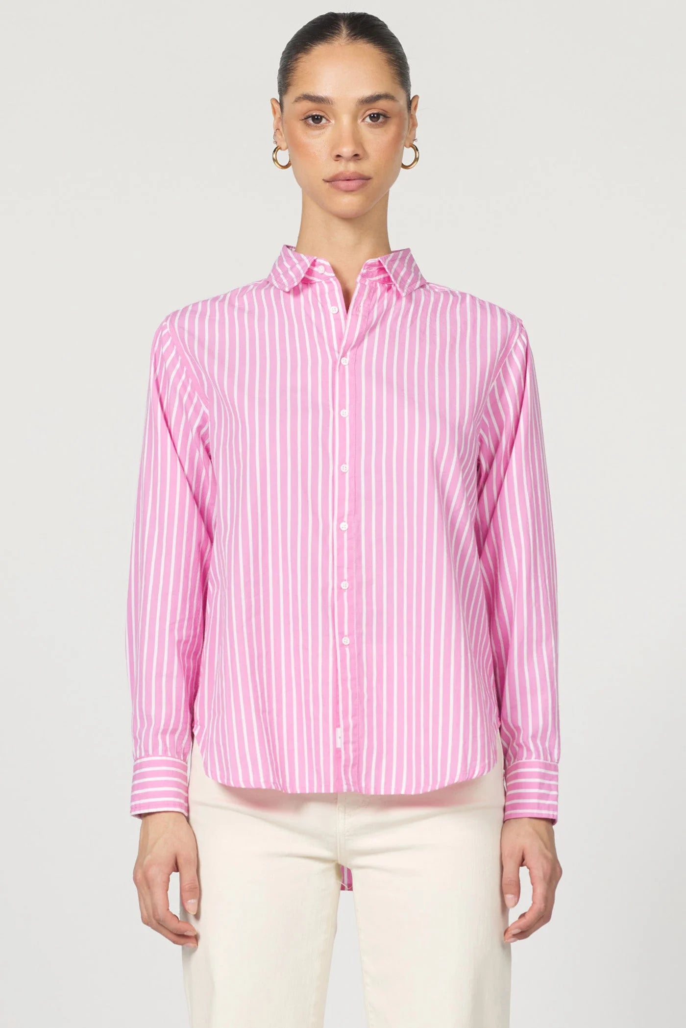 Woman wearing a pink and white striped shirt against a plain background