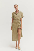 Woman wearing a beige shirt dress on a white background