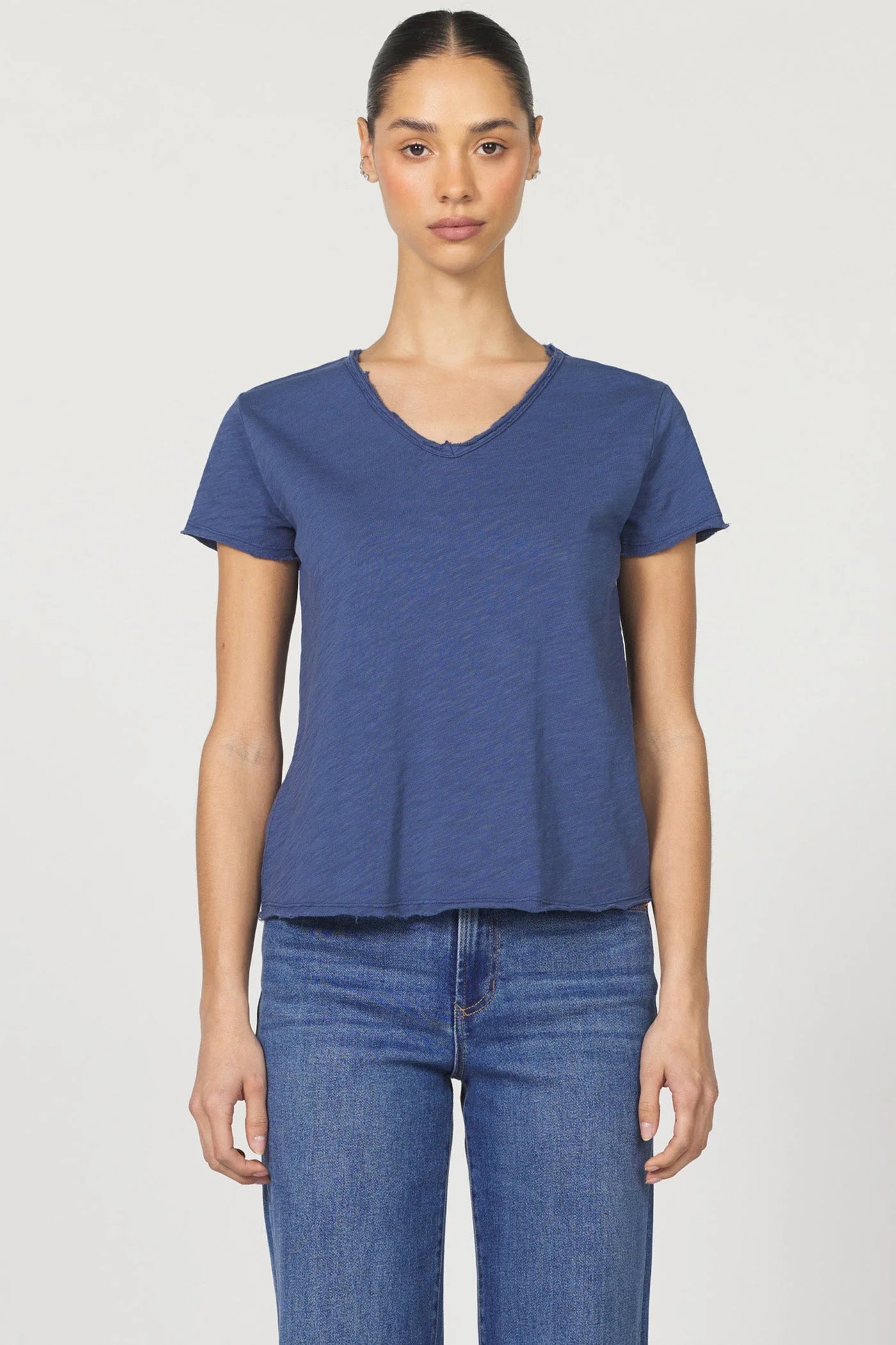 Woman wearing a blue t-shirt and jeans on a white background