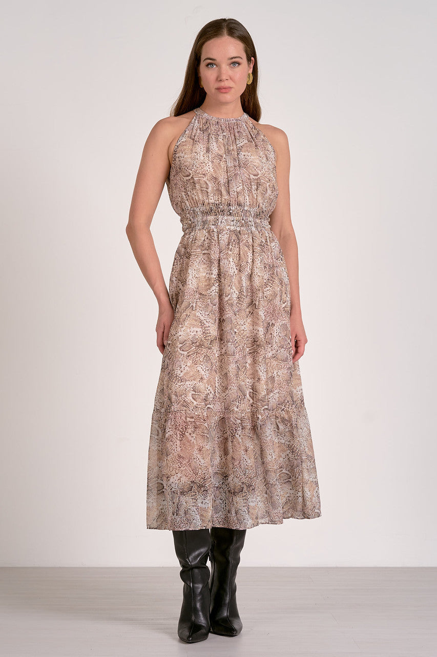 Woman wearing a patterned dress with black boots on a white background