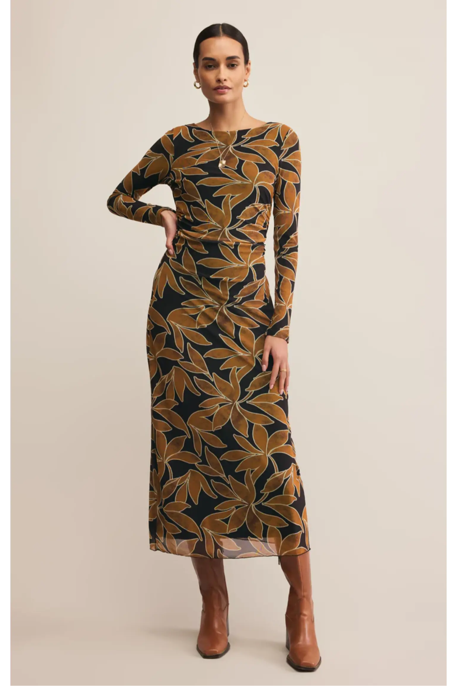 Woman wearing a patterned dress with long sleeves on a beige background