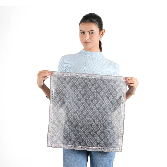 Woman holding flat dark grey paisley trellis bandana with pink border, white background