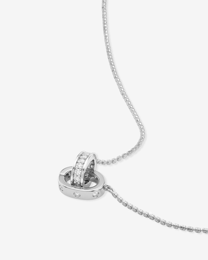 Close-up of Ashley Duo interlocked silver rings pendant with pavé crystals on beaded chain