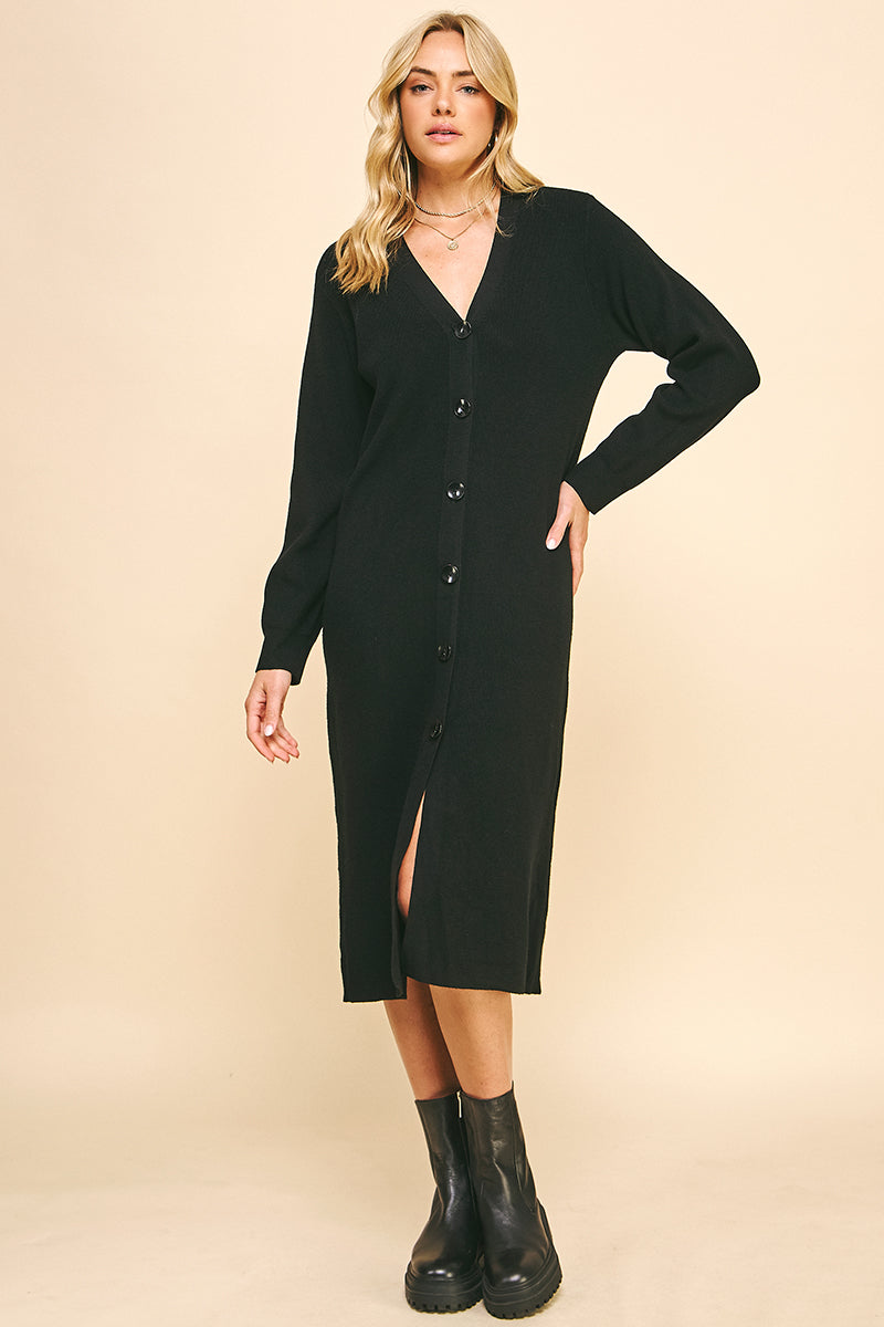 Woman wearing a black cardigan dress with a beige background