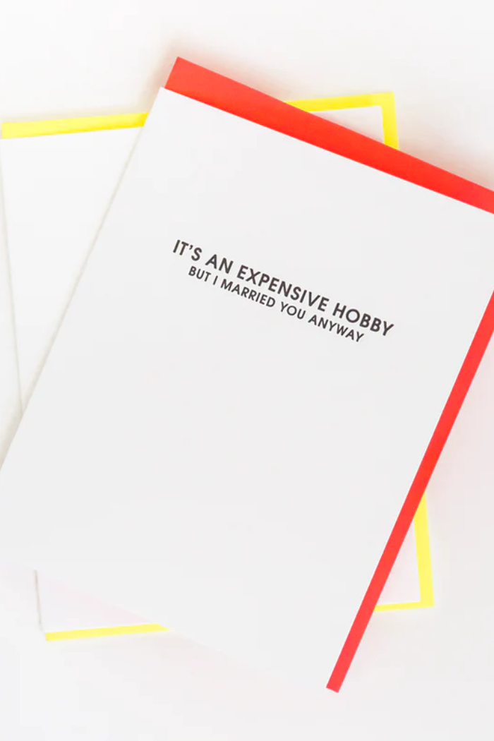Notebook with text 'It's an expensive hobby but I married you anyway' on a white background