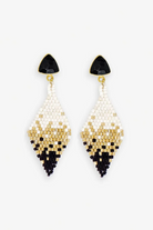 Pair of beaded earrings with black, gold, and white design on a white background