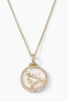 Gold necklace with a pendant featuring a zodiac design on a white background
