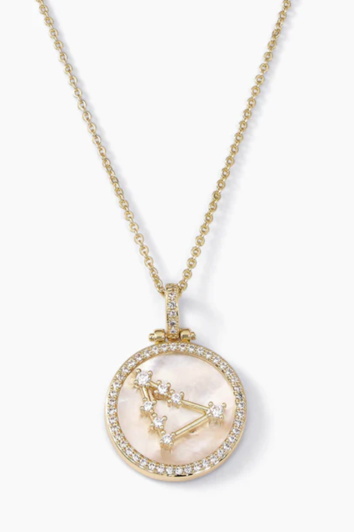 Gold necklace with a pendant featuring a zodiac design on a white background