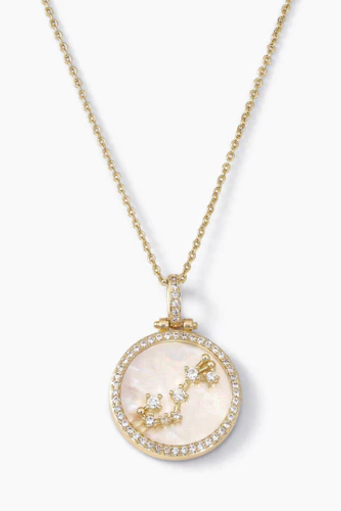 Gold necklace with a circular pendant on a white background