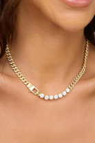 Gold chain necklace with embedded stones on a person's neck