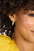 Close-up of a person wearing a colorful earring with a blurred background