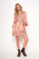 Woman wearing a patterned dress with a belt on a white background