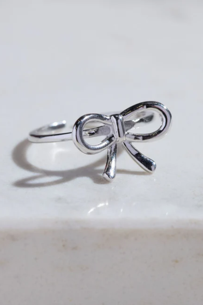 Silver bow-shaped ring on a light background