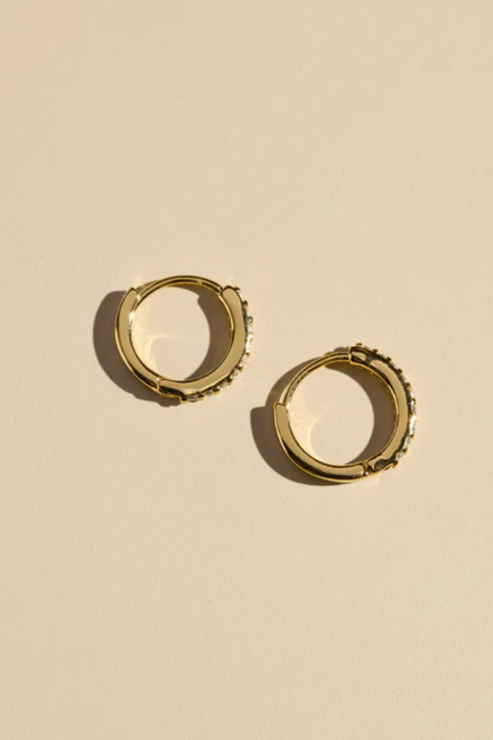 Gold hoop earrings on a beige background