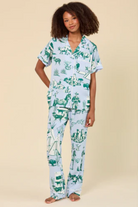 Person wearing a green and white pajama set with animal print on a beige background