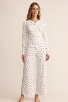 Woman wearing a white floral pajama set on a beige background