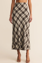 Plaid skirt worn by a person on a beige background