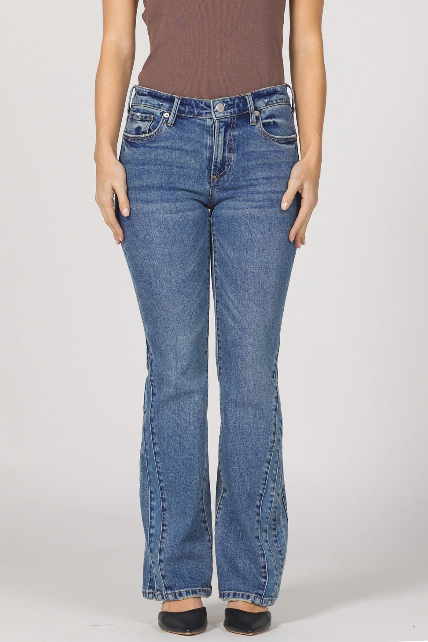 Blue jeans worn by a person on a plain background