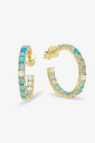 Gold hoop earrings with turquoise and white stones on a white background