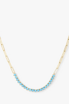 Necklace with blue beads on a gold chain against a white background
