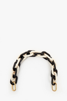 Black and white chain belt with gold hardware on a white background