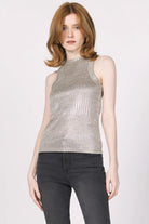 Woman wearing a silver sequin top and black pants on a white background