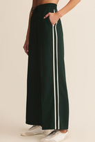 Green wide-leg pants with white stripes on a beige background