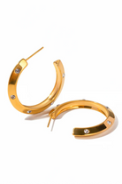 Gold hoop earrings with embedded stones on a white background