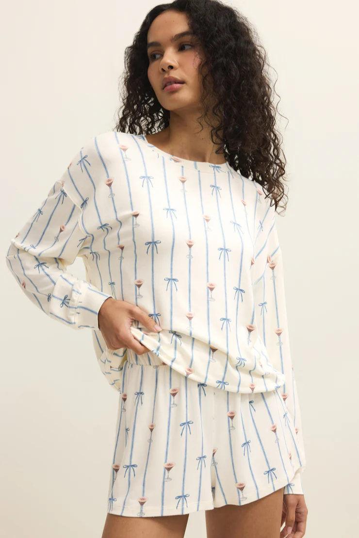 Woman wearing a long-sleeve top with a pattern on a plain background