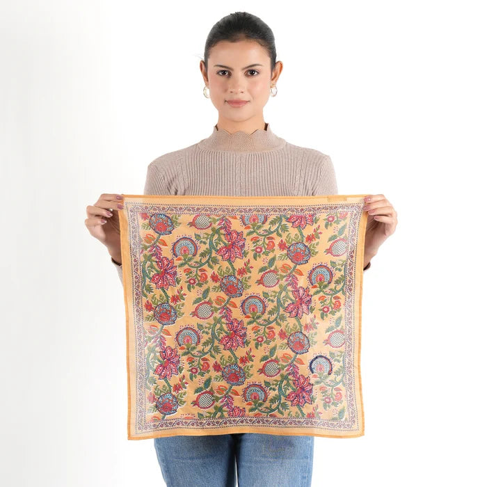 Woman holding flat Vismaya mustard floral bandana with pink and green print