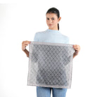 Woman holding flat dark grey paisley trellis bandana with pink border, white background