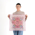 Woman holding unfolded pink floral Vismaya Florentine Bandana against white background