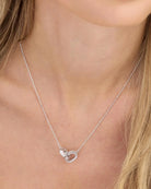 Ashley Duo silver necklace with interlocked diamond rings worn on woman's neckline