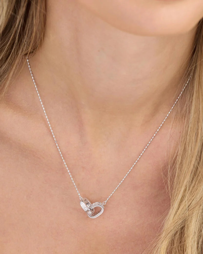 Ashley Duo silver necklace with interlocked diamond rings worn on woman's neckline