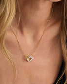 Blonde model wearing Ashley Duo Necklace gold and silver interlocked rings at neckline