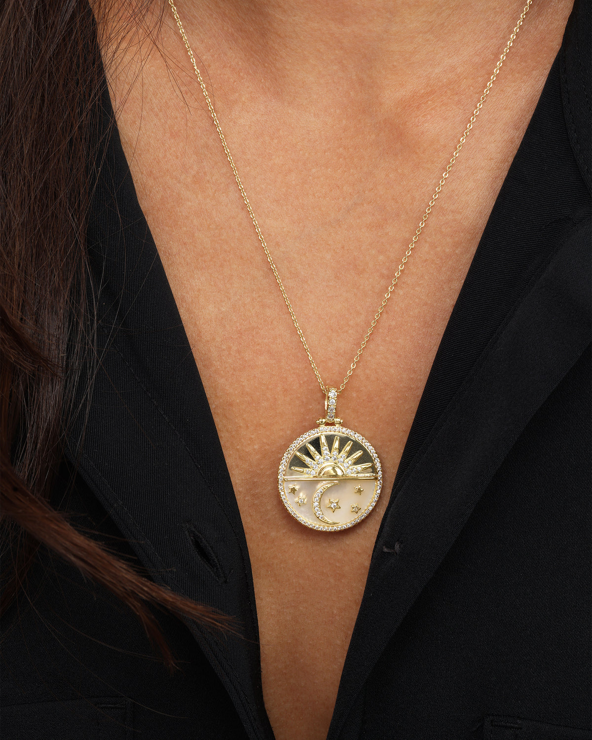 Melinda Maria gold celestial medallion necklace worn on model in black blazer, showing pendant scale at chest